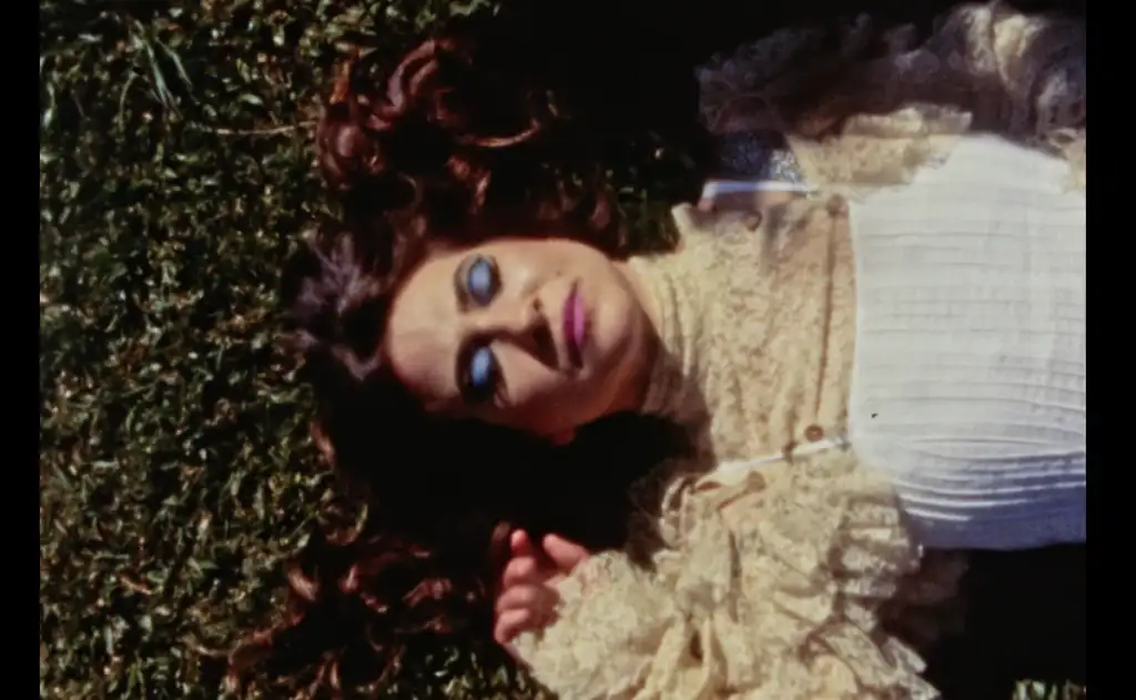 A foto mostra Uyara Torrente deitada na grama, com um vestido claro.