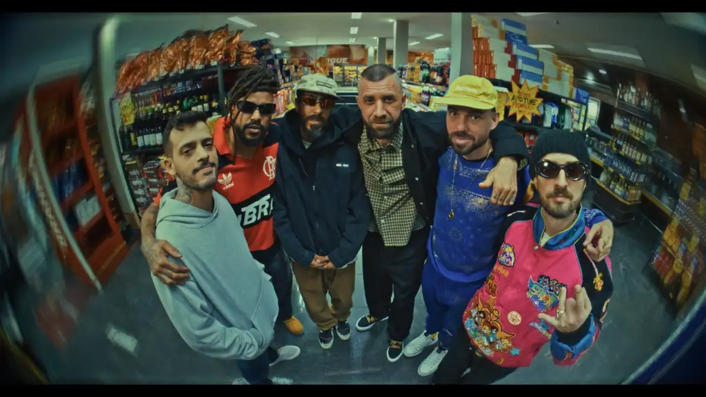 Após oito anos longe dos estúdios, o grupo ConeCrewDiretoria marca oficialmente seu retorno com o lançamento do álbum inédito “C.O.N.E” – acrônimo de “Caminhando Onde Ninguém Enxerga”. O projeto, composto por 17 faixas, reafirma a importância histórica da formação para o rap nacional, mergulhando no boombap, nas rimas afiadas e na estética que consagrou o grupo na última década. O disco reúne a formação original – Ari, Batoré, Cert, Maomé e Rany Money – e conta com produções de Papatinho, que explorou elementos clássicos do gênero. “Acho que a gente conseguiu fazer um álbum bem a cara do grupo”, afirmou o produtor, um dos nomes mais influentes da cena atual. Além da base histórica, “C.O.N.E” traz participações de peso como Major RD, Black Alien e Orochi, encontros que reforçam a relevância do ConeCrew tanto para a velha quanto para a nova geração do rap brasileiro. A faixa foco, “Dadinho é o Crlh”, chega acompanhada de videoclipe superproduzido, reforçando o impacto do retorno do grupo